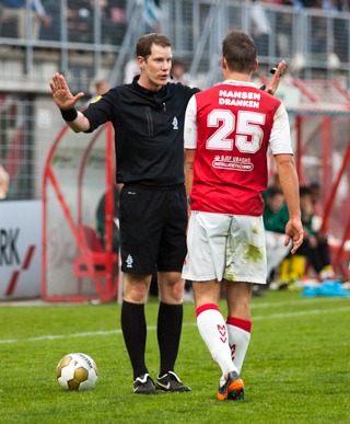 Jeroen Sanders als scheidsrechter in gesprek met een MVV-speler